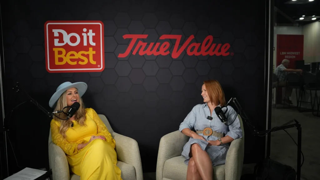 Stefanie Couch at the microphone interviewing a guest on the Do it Best podcast set