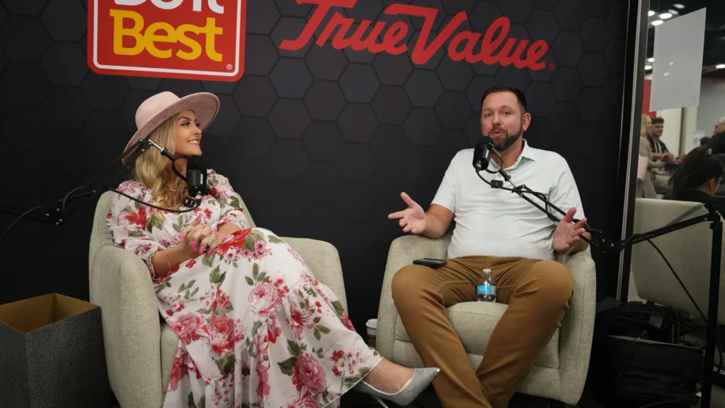 Stefanie Couch interviewing a guest on the Do it Best podcast set, seen wide