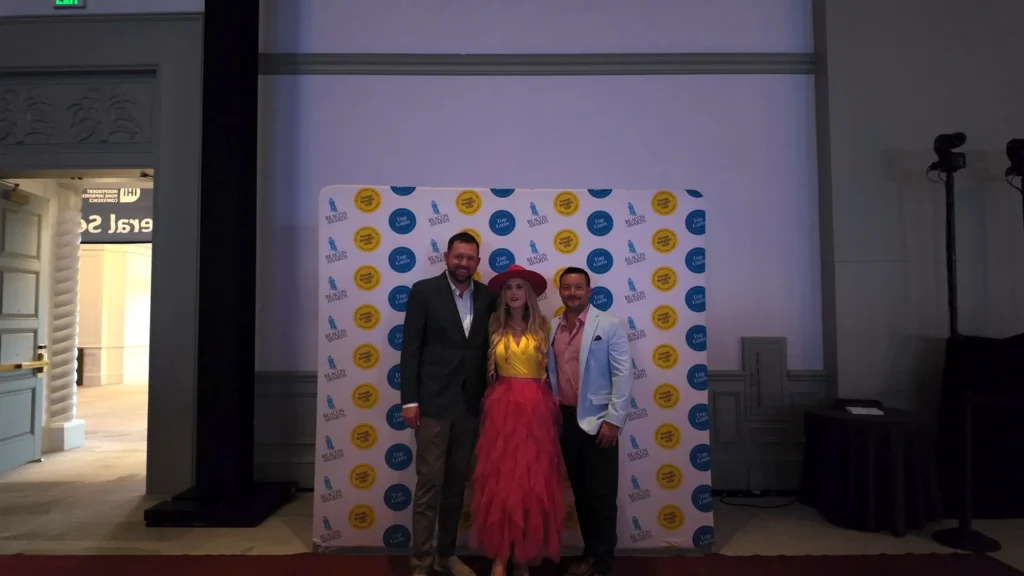 Stefanie Couch with two attendees at a photo backdrop at the Independent Home Improvement Conference 2026