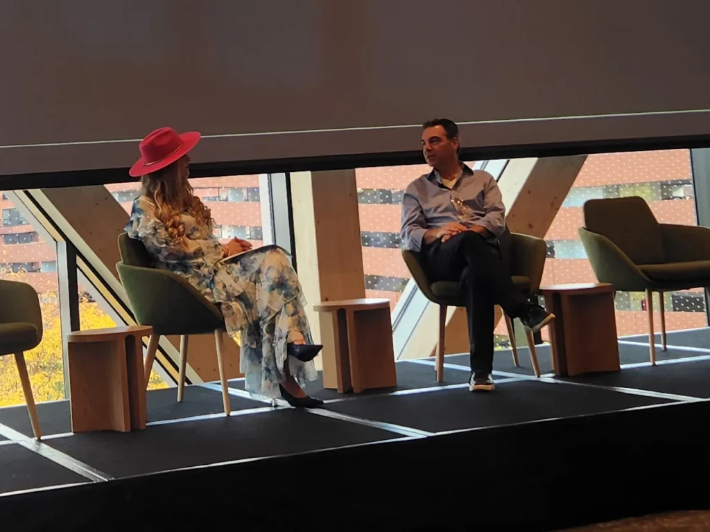 Stefanie Couch in a pink hat hosting a fireside chat with a guest on stage at the WDMA Executive Leadership Forum 2026