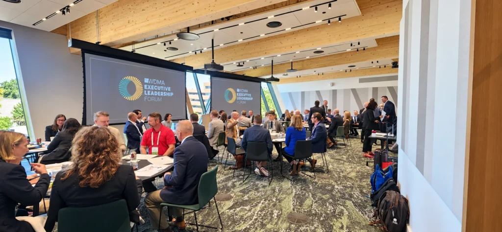 Leaders talking at round tables under the two WDMA Executive Leadership Forum screens