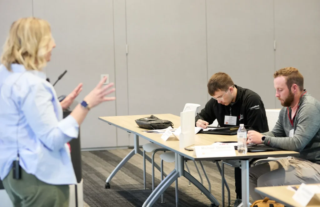 A Grit Blueprint presenter working with attendees at their table at the Do it Best LBM Millwork Academy