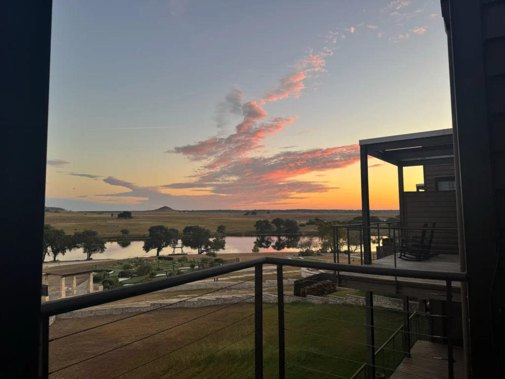 Dawn over the lake and ranch land from a balcony at Rough Creek Lodge