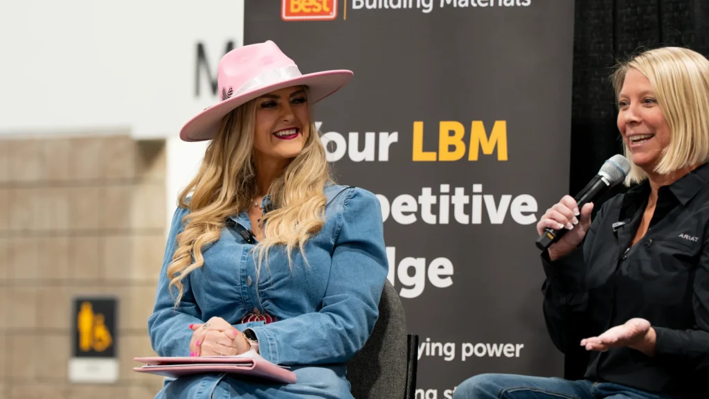 Stefanie Couch moderating the marketing panel at Do it Best Spring Market 2026, notes in hand, as a panelist answers into a microphone